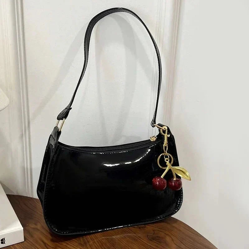 Women's pure leather cherry pendant handbag by TrendLux Wear, solid color with a stylish cherry-shaped pendant detail.
