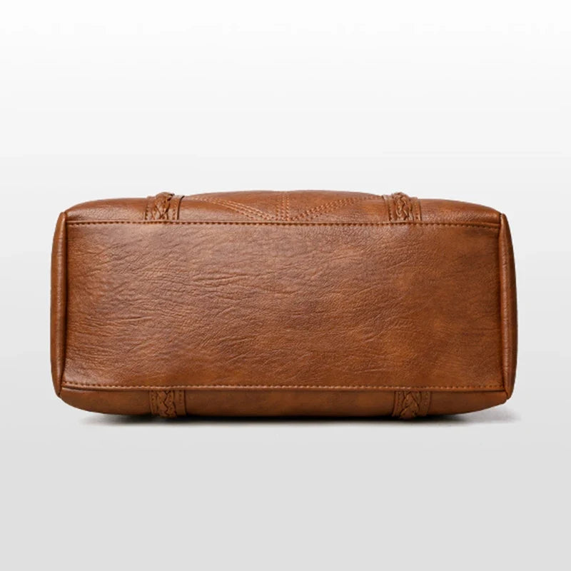 Soft brown leather handbag with a casual tote shape, featuring stitched details and a zip closure.