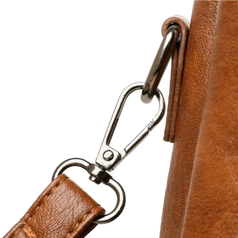 Brown leather strap with a silver metal clip, showcasing the attachment detail of a designer handbag.