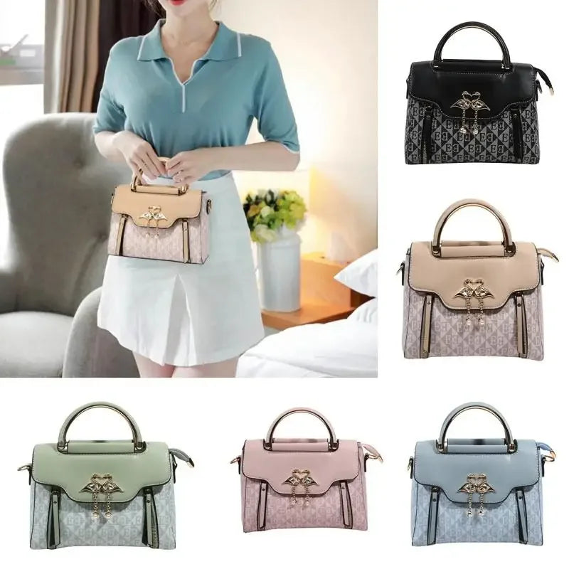 Ladies' handbag in pale pink with a structured design, featuring a top handle and metal accents, worn as a crossbody.