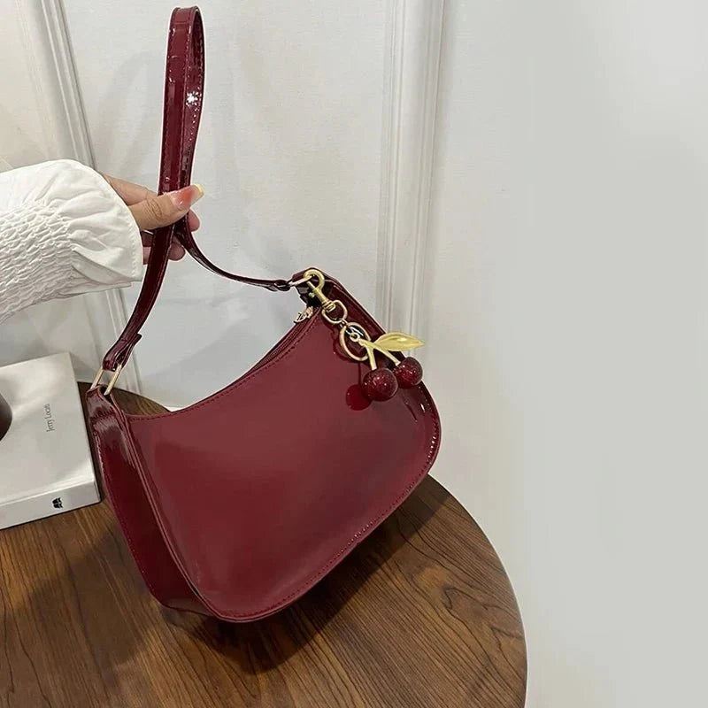 Women's Pure Leather Cherry Pendant Handbag by TrendLux Wear, solid color handbag with cherry pendant detail.