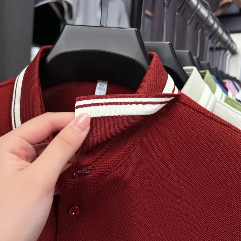 Burgundy short sleeve polo shirt with a striped collar and button detail, made from breathable cotton fabric.