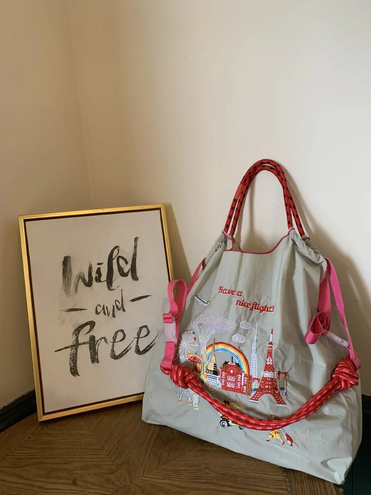 Light grey nylon tote bag with pink accents, featuring colorful embroidery and a large capacity for casual use.