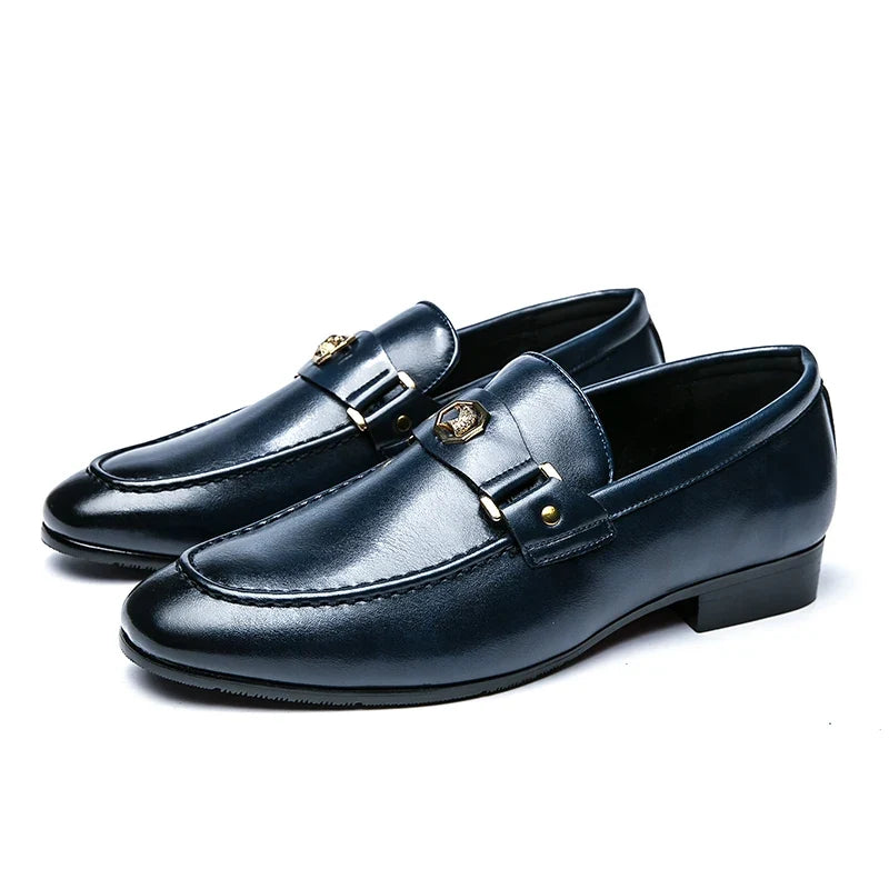 Navy blue leather slip-on loafers with a round toe and a metal buckle detail, perfect for formal occasions.