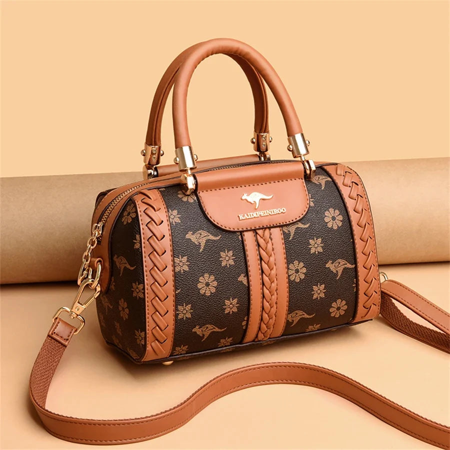 Brown semi-woven handbag with floral and kangaroo patterns, featuring dual handles and an adjustable shoulder strap.